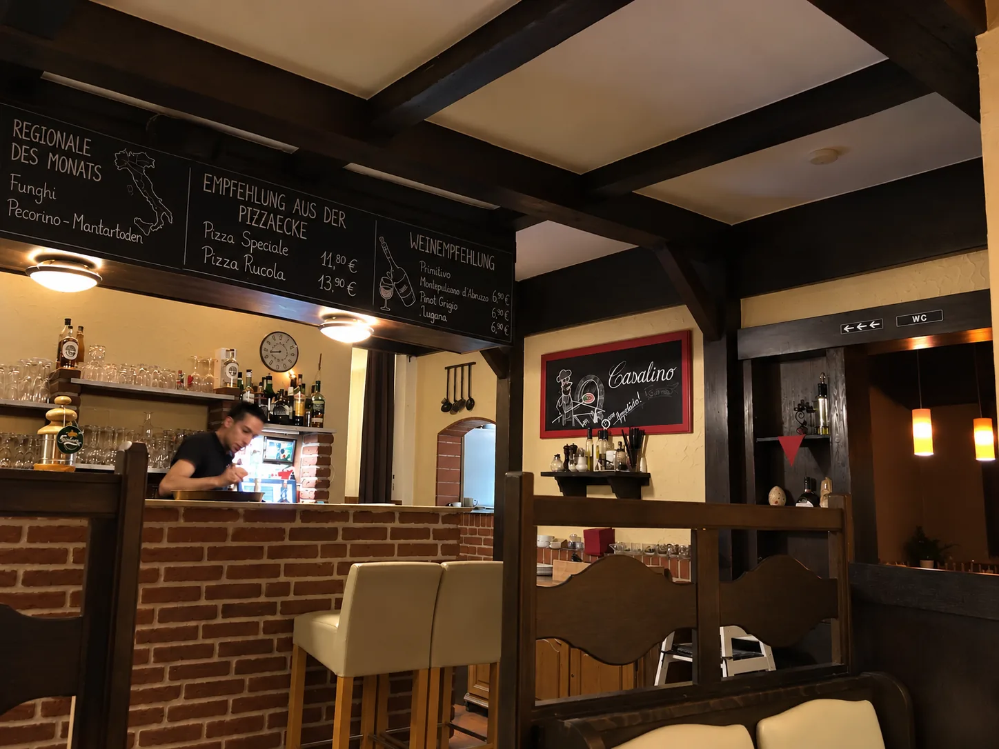 Tresen und Gastraum der Pizzeria Casalino mit Kreidetafeln